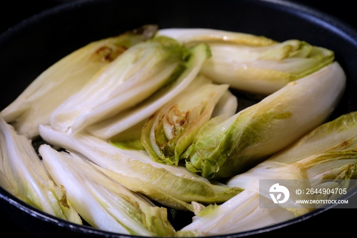 Endives braisées dans une poêle.