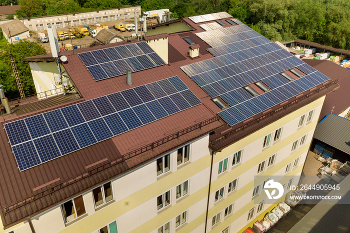 Aerial view of many solar panels mounted of industrial building roof.