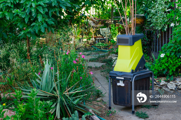 Small portable electric woodchipper in a garden