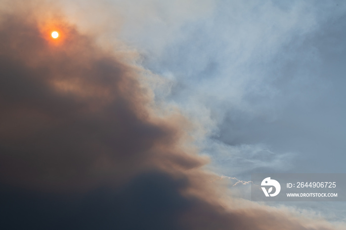 Smoke flume from the Cameron Peak fire in Colorado partially obscures an orange tinted sun