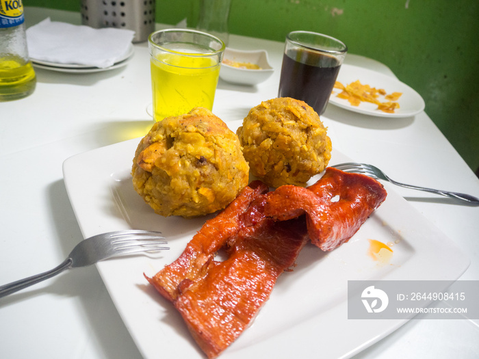 Peruvian food: tacacho with cecina served on a white plate at a local market