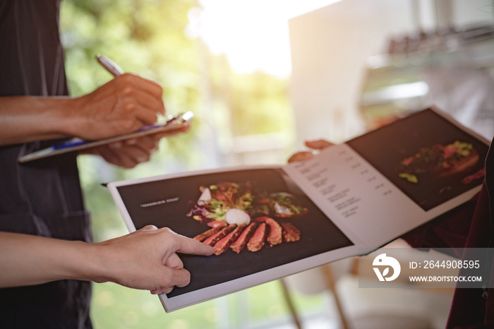 People are reading the menu and ordering food in the morning restaurant.