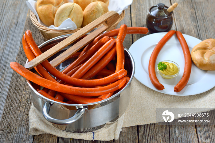 Pikante Debreziner Würstchen im Topf serviert mit Semmeln und scharfem Senf  – Hot debreziner sausages in a cooking pot served with fresh rolls and spicy mustard