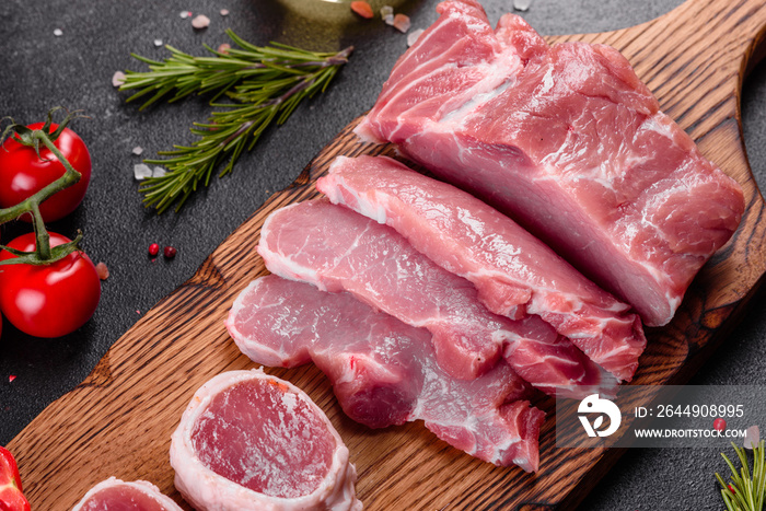 Fresh pieces pork ready to cook on a dark background in the kitchen