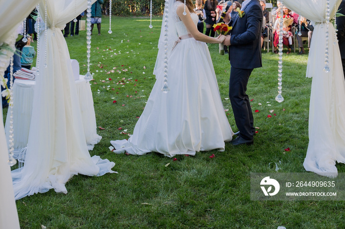 bride and groom near arch of the wedding ceremony