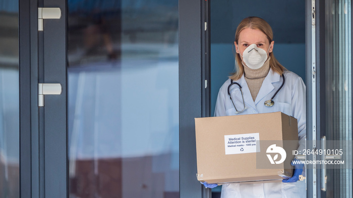 Portrait of a doctor with a box of protective medical masks.