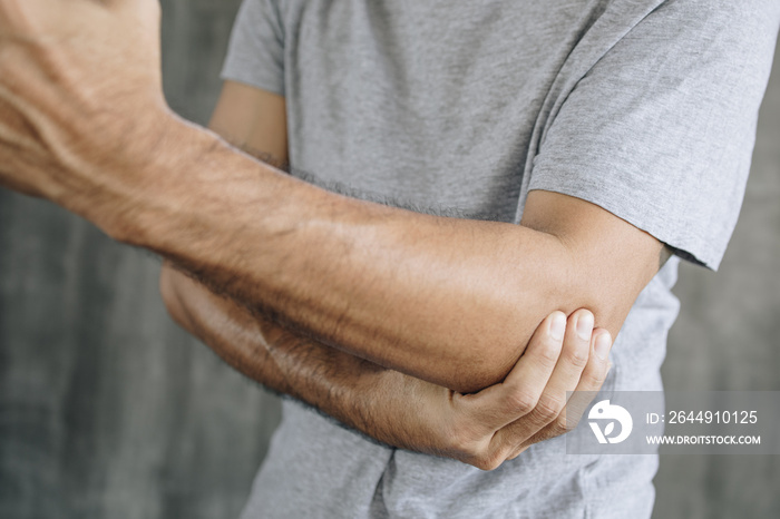 Close up of man suffering from pain in hand or elbow