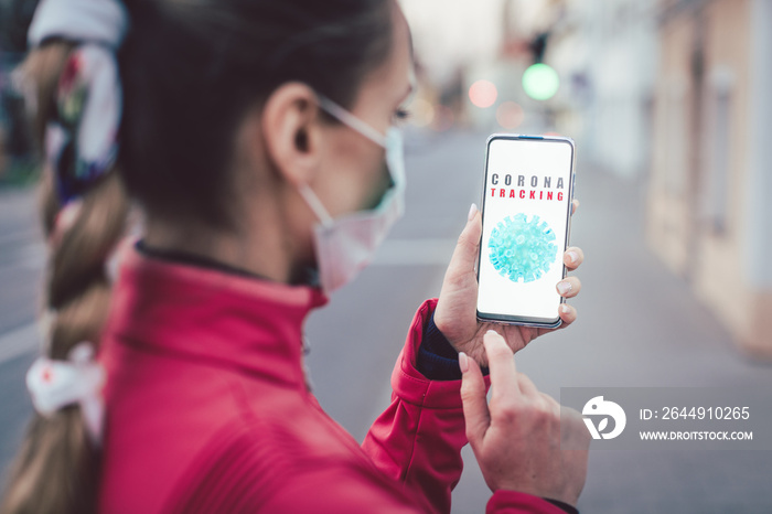 Woman using a phone with the coronavirus tracking app installed