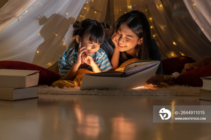 Happy family asian mother and daughter reading a book