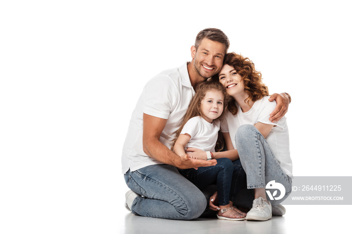 happy man hugging cheerful wife and daughter on white