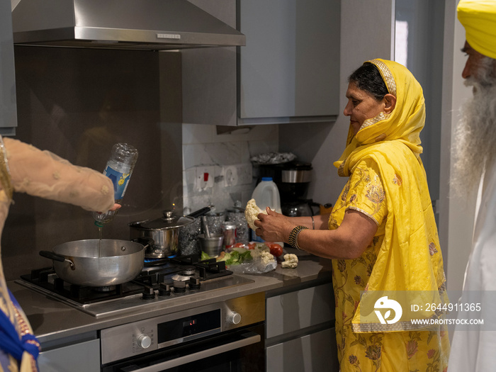 Family in traditional clothing cooking meal together