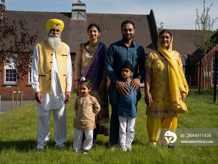 Portrait of three-generation family (2-3,6-7) in traditional clothing