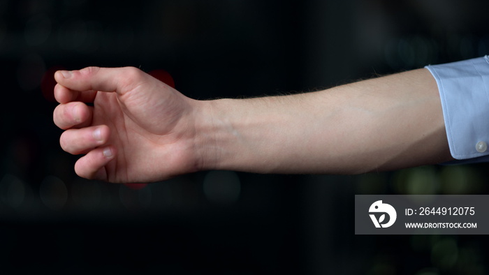 Macro of man hand rolling sleeve on black background. Man hand touching botton