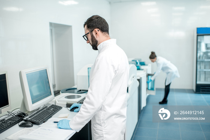 Male technician working with analyzer machine at the laboratiry