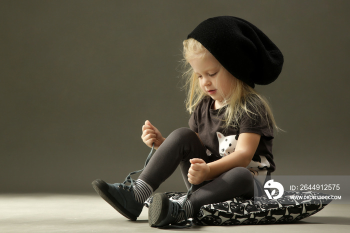 Cute toddler girl learning to tie shoelaces