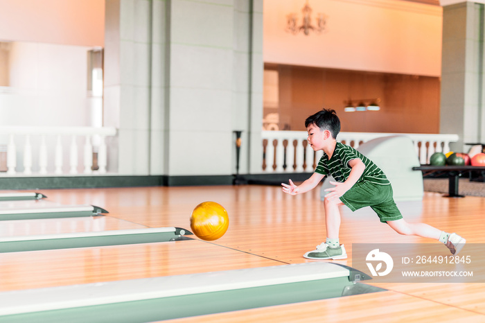 Cute child with ball in bowling club.