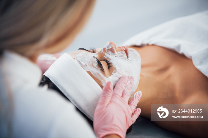 Close up view of woman that lying down in spa salon and have face cleaning procedure by the mask