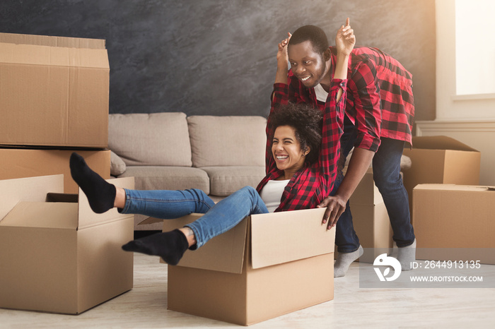 Young black couple unpacking moving boxes