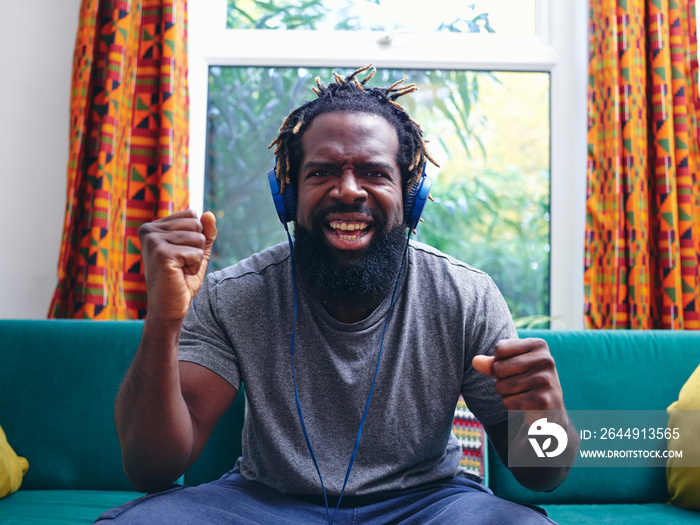 Portrait of man listening to music on headphones