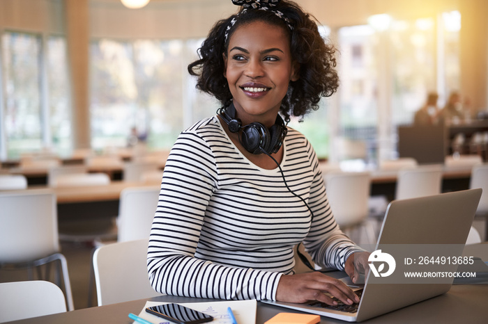 Smiling young African college student doing homework on campus