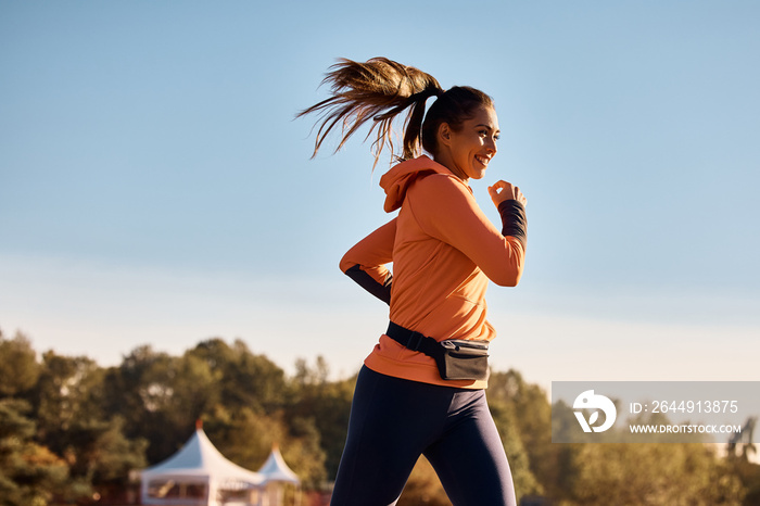 Happy athletic woman enjoys in jogging in nature.