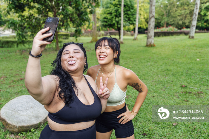 Friends taking photos of each other in the park after a workout