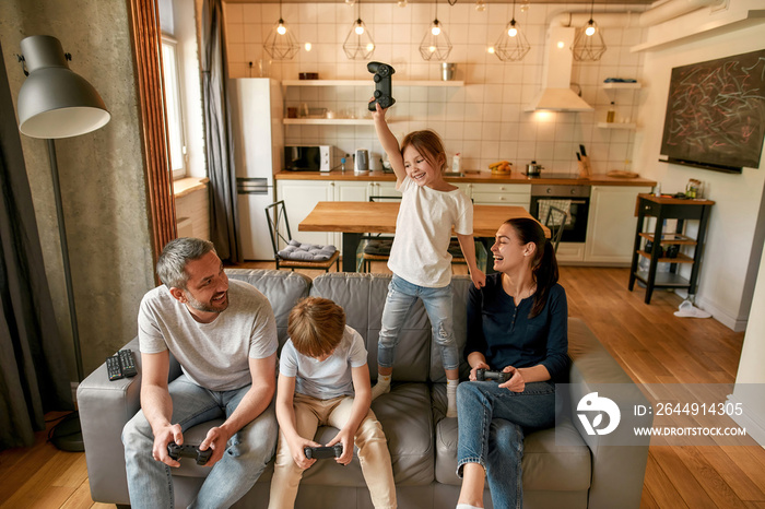 Excited little girl celebrate win playing video game