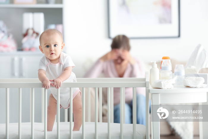 Depressed young woman with cute baby at home