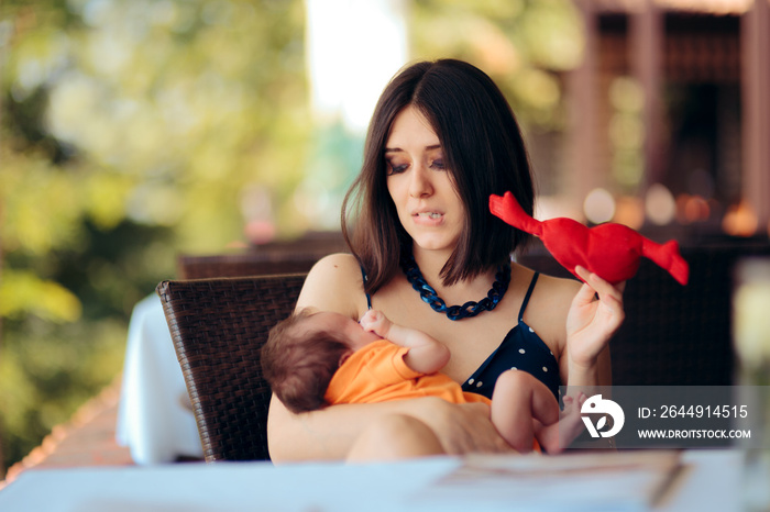 Mother Holding Toy Calming her Crying Baby in a Restaurant