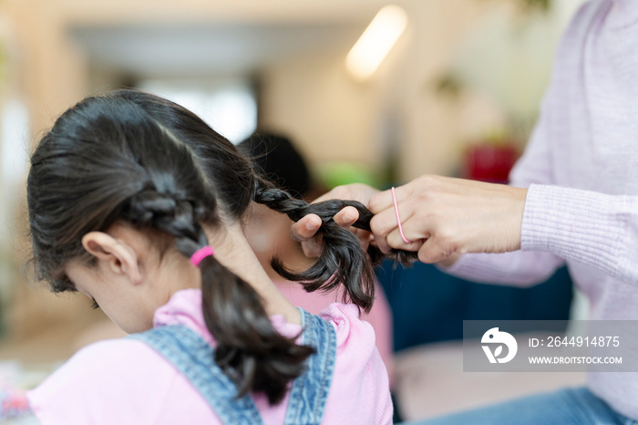 Mother doing daughter braids