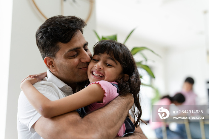 Father hugging daughter at home