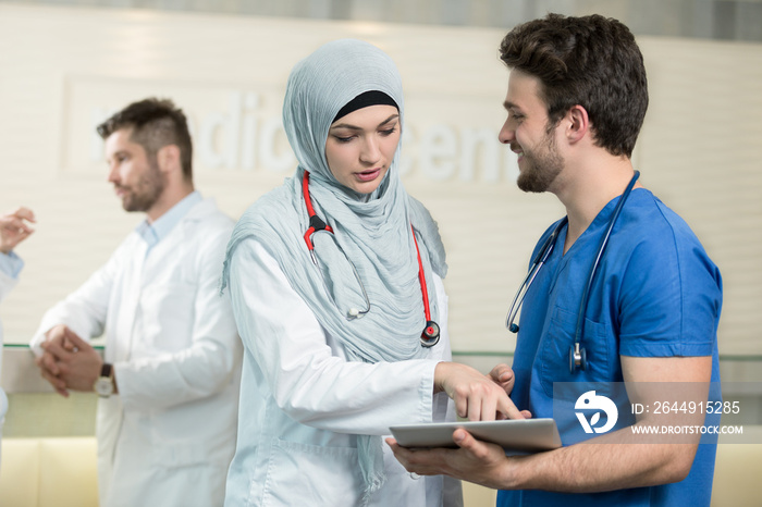 Saudi arab doctors working with a tablet.