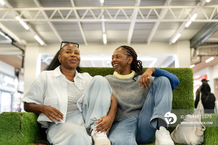 Young women relaxing on sofa in shopping center