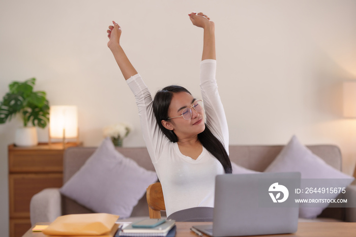 Beautiful Asian woman working at home relaxing by Stretching to relieve fatigue from sitting in the same place for a long time.