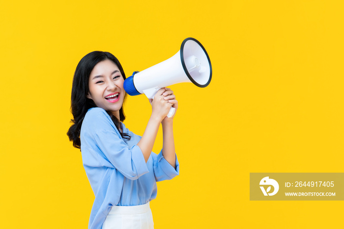 Beautiful Chinese woman cheerfully using magaphone