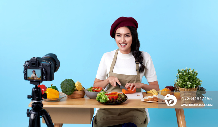 Happy asian young woman in fashion look style and shooting video with camera cooking food healthy is blogger presenting for social people.Her is influencer in social online.