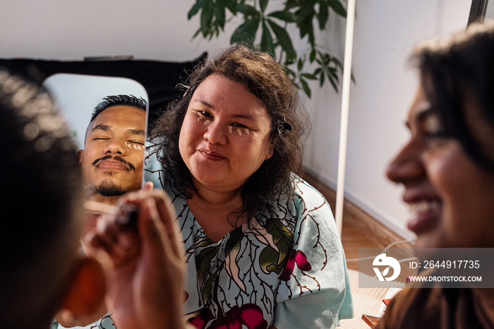 Group of friends doing each others make up at home during a sleepover