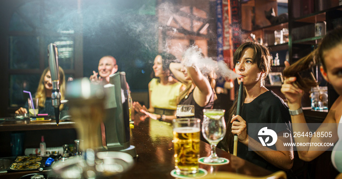 group of people smoking hookah in bar