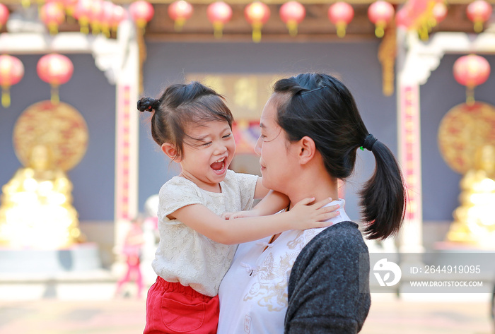 portrait of mother and cute little girl in Yaowarat Road (Bangkok chinatown) at Chinese new year, Bangkok Thailand.