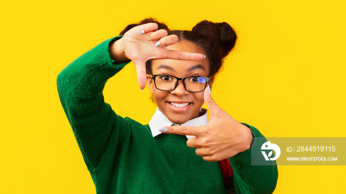 Smiling afro teenager making frame with hands