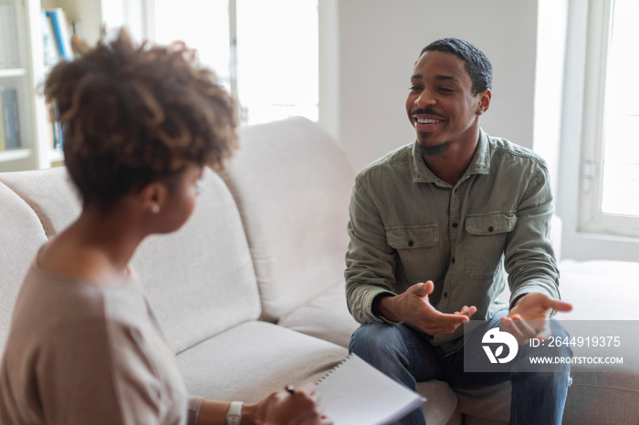 Cheerful positive african american guy having conversation with therapist