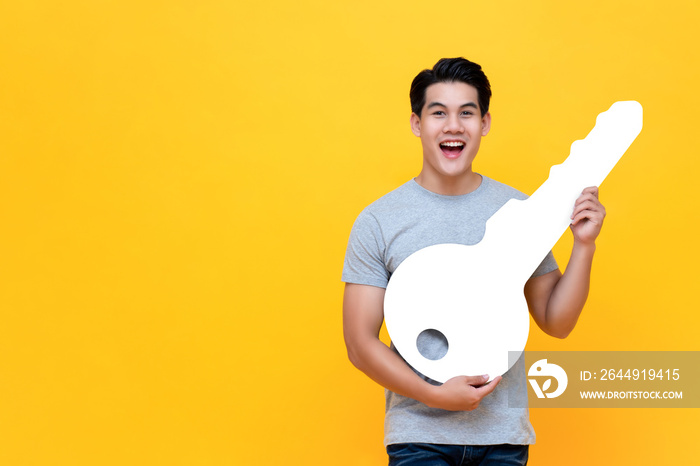 Excited young Asian man holding big mockup car key