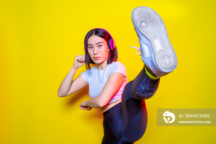 Portrait of young woman practicing kickboxing indoors