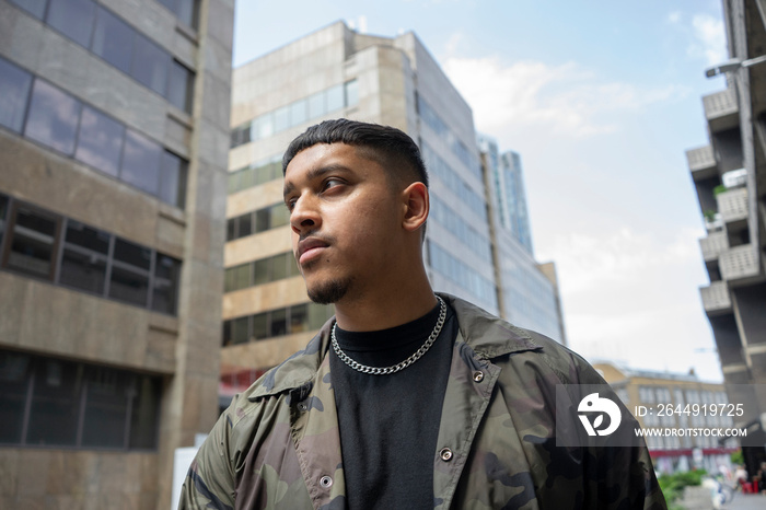 Young man wearing camouflage jacket,black tshirt and necklace