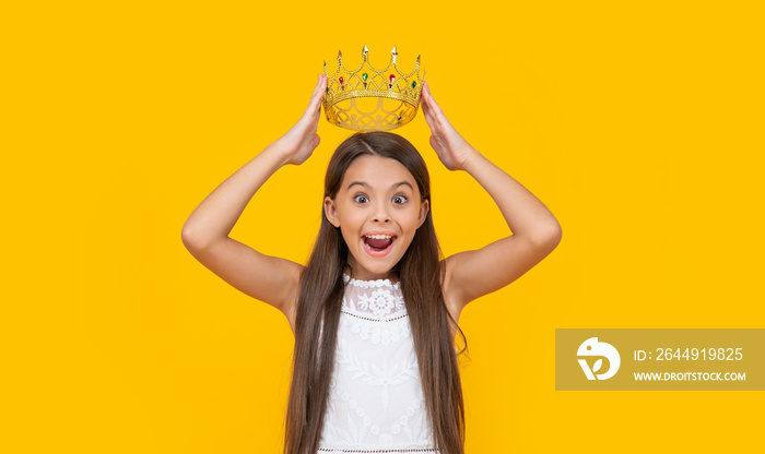 amazed teen girl in crown on yellow background