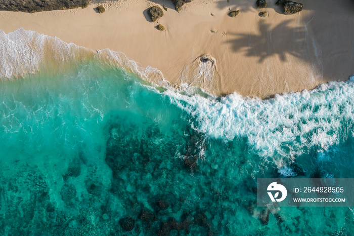 Aerial drone top view shot of rocky beach with cliff. Indian ocean shore. Copy space for text. Nature and travel background. Beautiful natural summer vacation travel concept. Waves and sand.