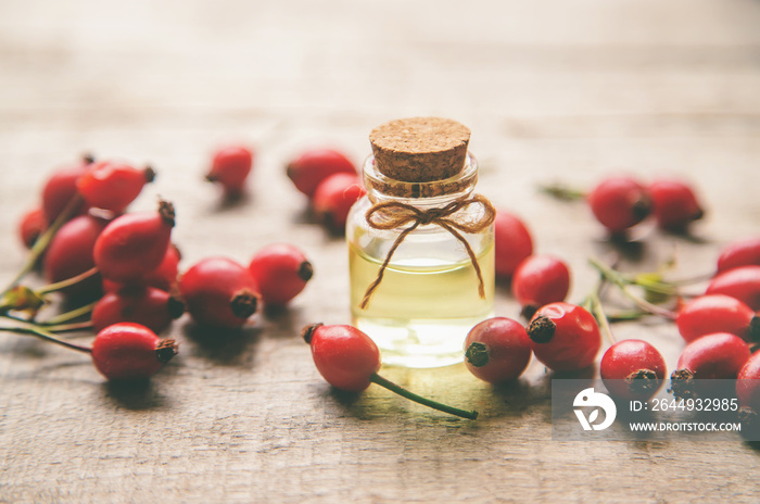 Rosehip seed essential oil in a small bottle. Selective focus.