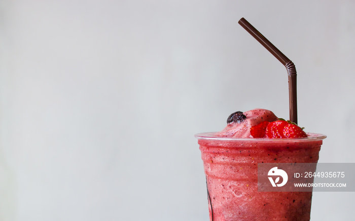 Closeup top of strawberry and blueberry smoothies in plastic cup. Refreshment healthy drink. Copy space with white background.