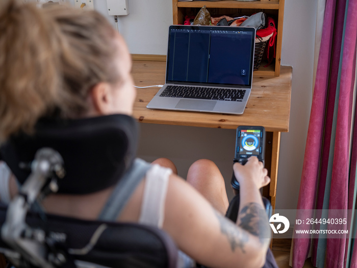 Woman in electric wheelchair working on laptop