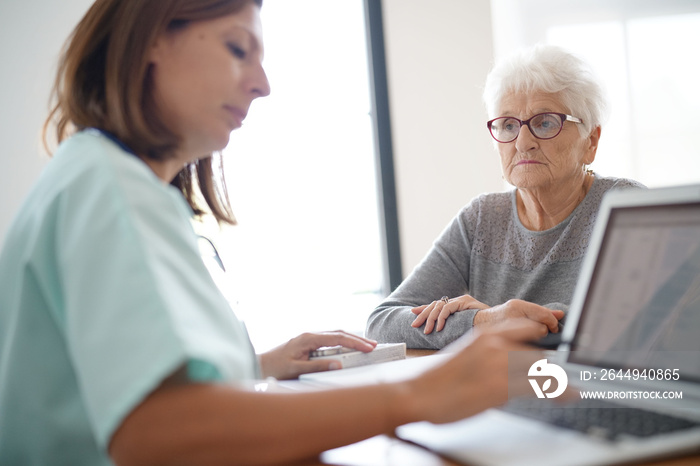 Nurse giving prescription to elderly woman